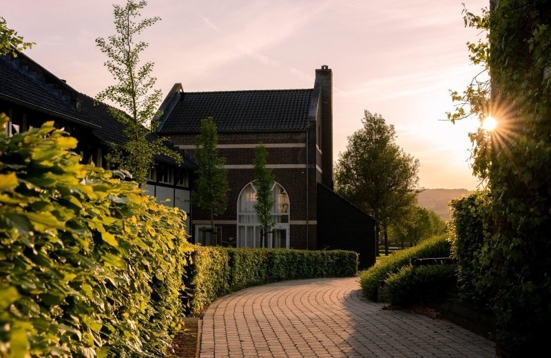 Vakantiehuis in Limburgse vakwerkstijl bij zonsondergang op De Mechelerhof bij Maastricht