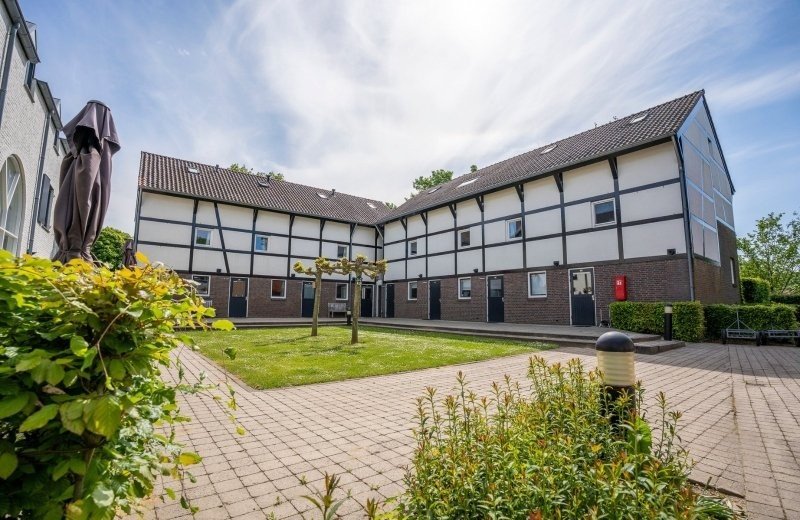 Binnenplaats met authentieke vakwerkhuizen op Vakantiepark Mechelerhof bij Maastricht
